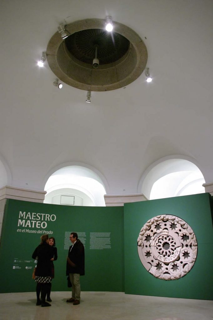 Sobre estas líneas, en el panel, uno de los rosetones que albergó la antigua fachada occidental de la catedral compostelana y en el techo, el óculo neoclásico abierto en la bóveda de la rotonda baja del museo. Arriba, una vista de la sala de la exposición Foto © Museo Nacional del PradoFoto © Museo Nacional del Prado.